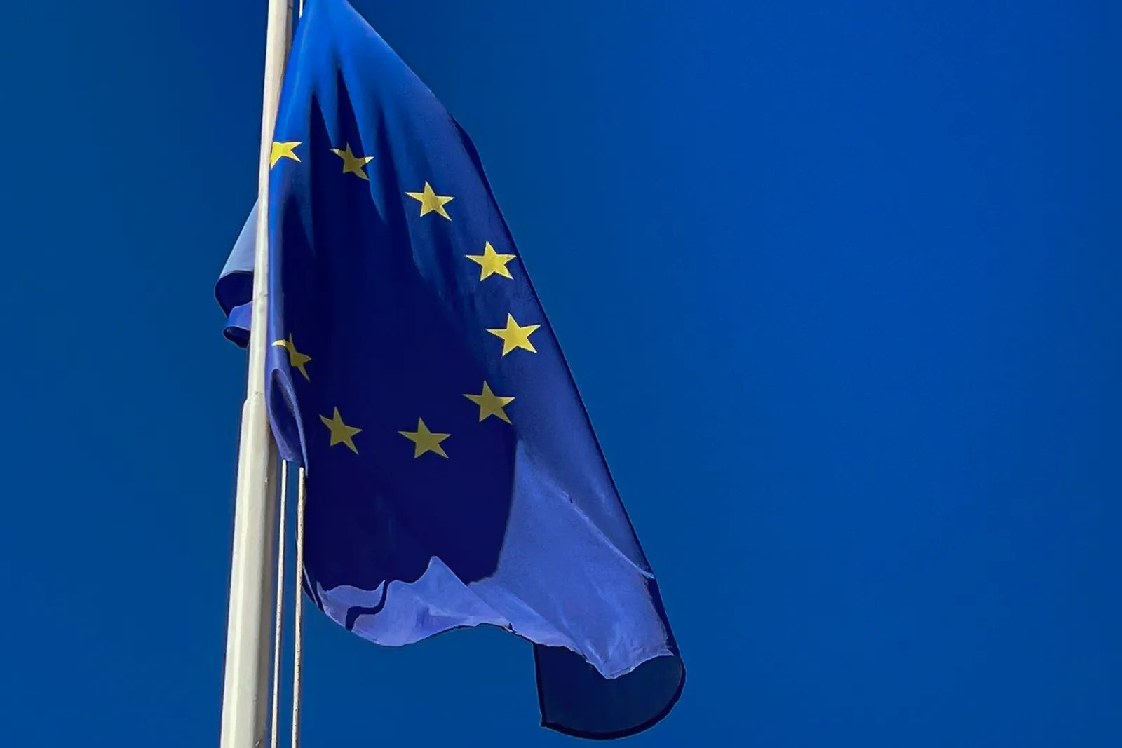 Az Európai Unió lobogója mélykék égbolt előtt