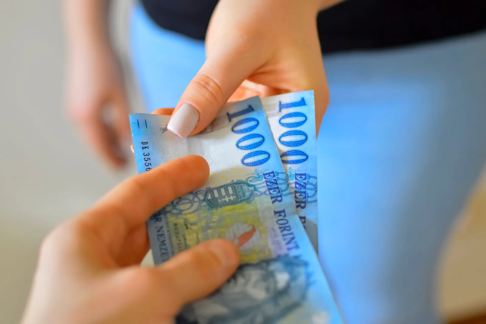 Ezerforintos bankjegy kézből kézbe